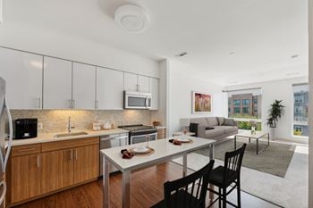 A modern kitchen with wooden cabinets and a dining table with chairs.